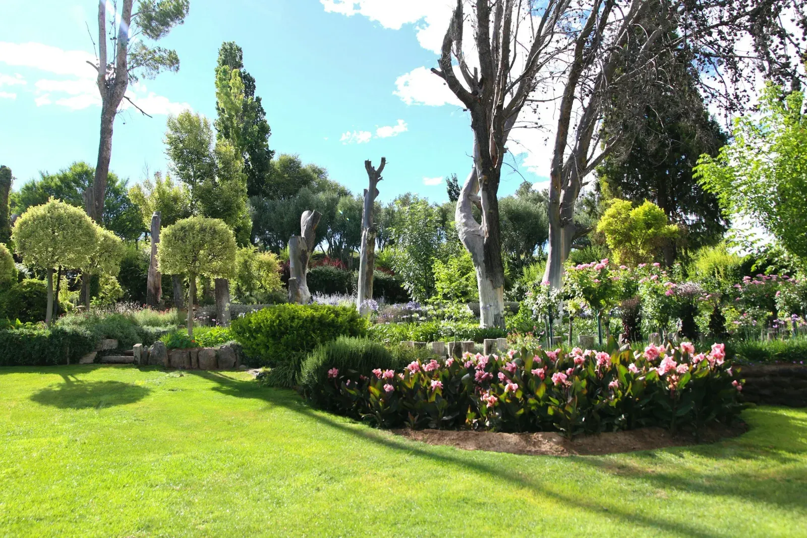 Parkähnlicher Garten mit Formgehölzen und Blütenbeeten