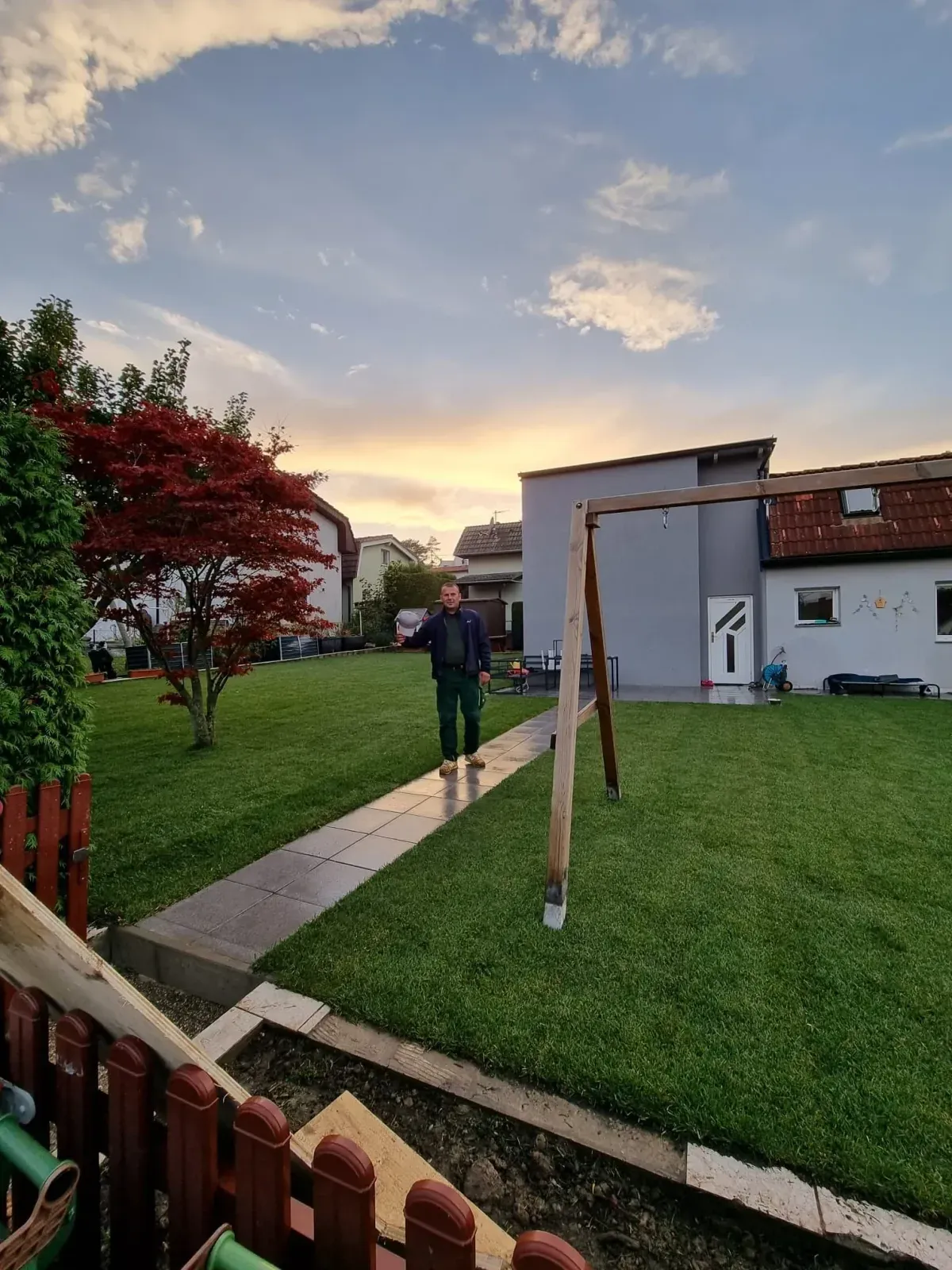 Ilir Musaj in einem fertig gestalteten Garten bei Sonnenuntergang